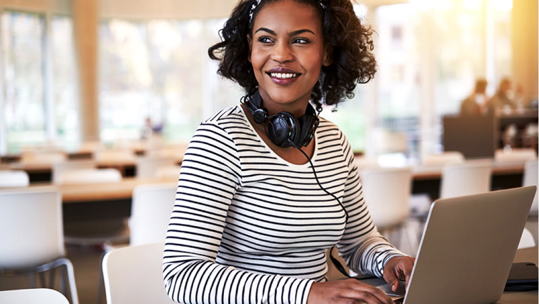 Woman smiling and working on laptop